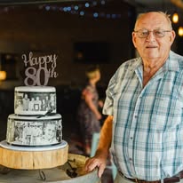 Guest of honour beside a tiered cake at a milestone birthday celebration