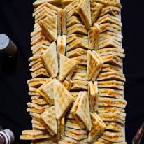 A platter stacked with freshly made toasted sandwiches