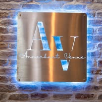Illuminated Annerkant Venue sign on a brick wall at night