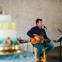 Acoustic guitarist performing at an event in the hall