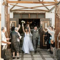 Newlyweds celebrating with guests at the venue doors after the ceremony