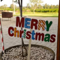 Colourful Merry Christmas sign in a planter at the venue entrance